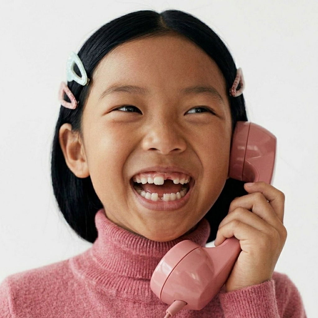 Enfant avec un téléphone combine rose