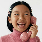 Enfant avec un téléphone combine rose