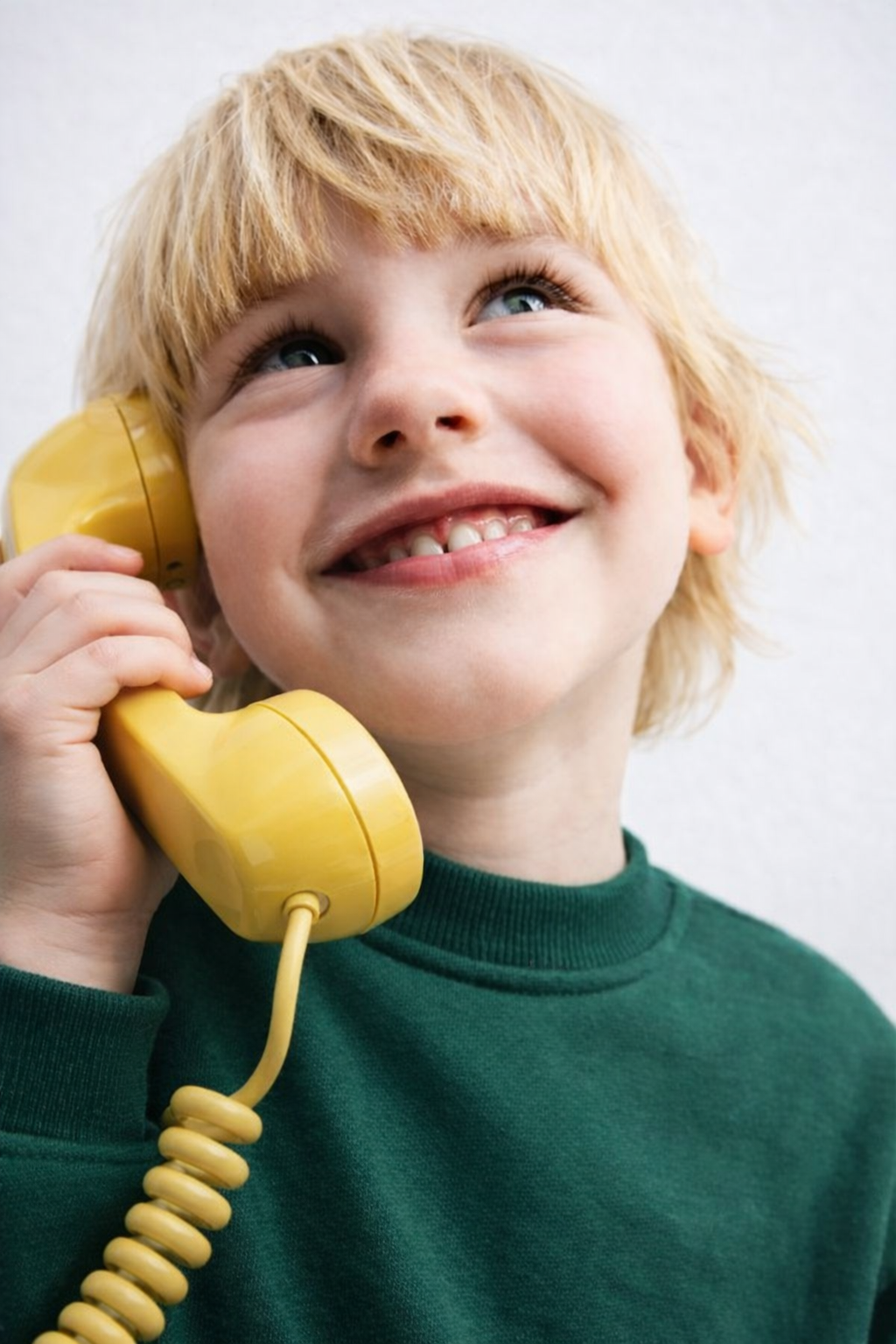 Petit garçon avec un téléphone Combiné jaune